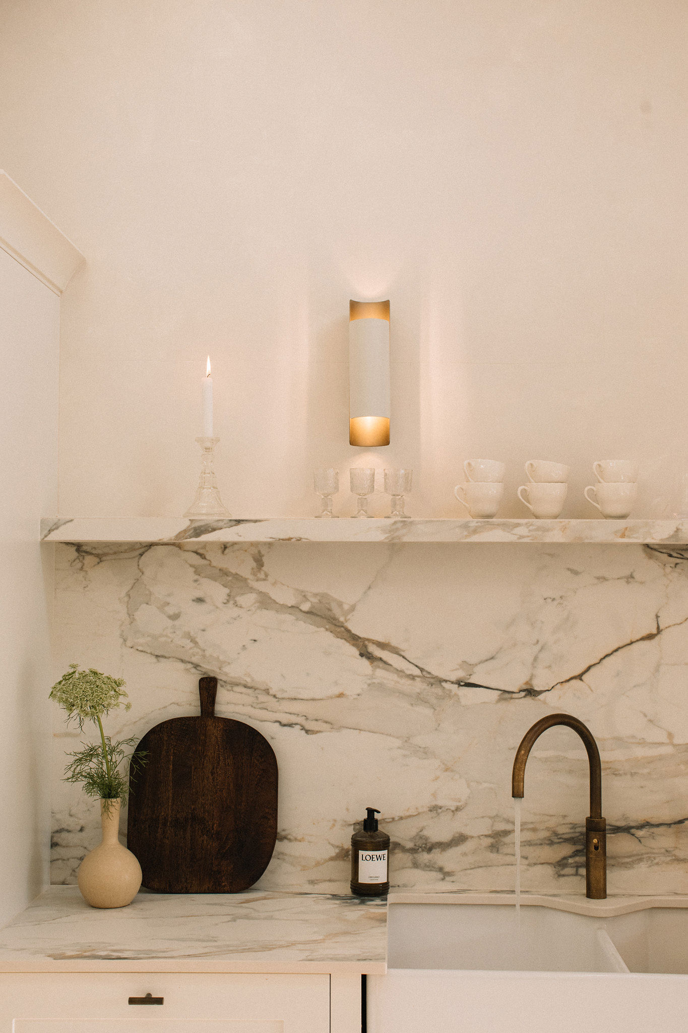 Marble kitchen detail with brass tap and walnut chopping board