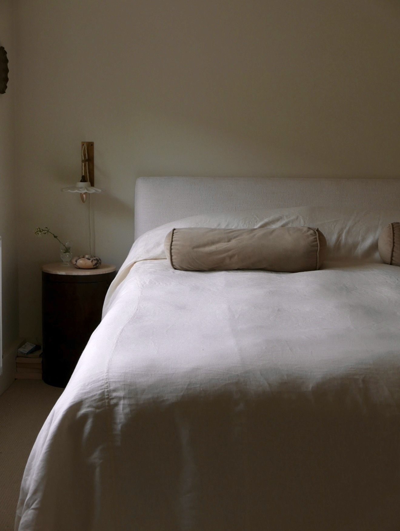 Bed styled with a linen bolster pillow